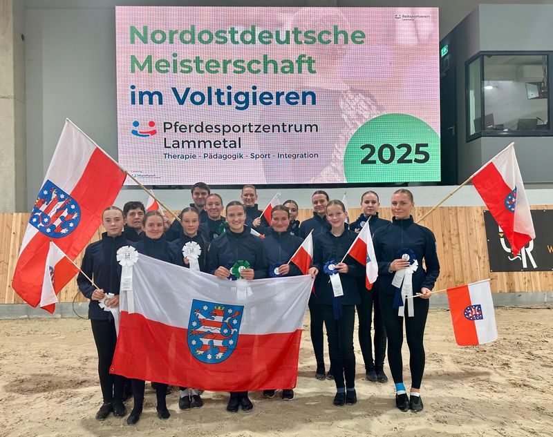 Gruppenshooting von Voltigierern mit Flaggen und Banner der Nordostdeutschen Meisterschaft 2025.